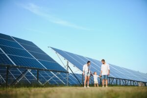 About 7 A wide shot of a happy family standing together and smiling at camera with a large solar panel
